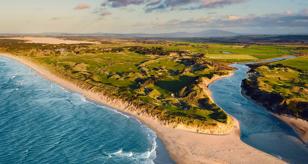 Illustrative elevated view of a Tasmanian coastal links golf course with rolling dunes, fairways and surf along the shoreline, for a Barnbougle golf trip.